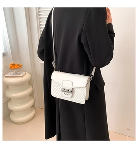 Detail view of the white crossbody bag with elegant diamond quilting and silver ring clasp