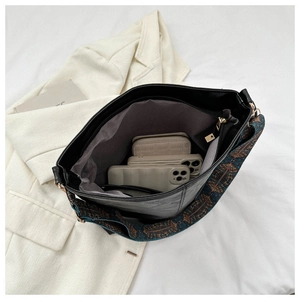 Detail of black large capacity bag with ethnic embroidery strap and interior pocket