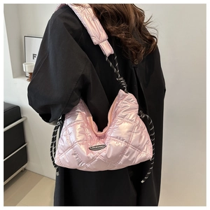 Close-up of pink quilted puffer shoulder bag with a fashion logo and woven rope detail