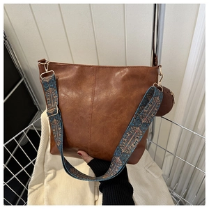 Detail of retro brown tote bag with colorful bohemian guitar strap and round coin purse