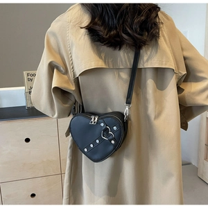 Vue détaillée du sac bandoulière noir en forme de cœur avec clous et boucle cœur