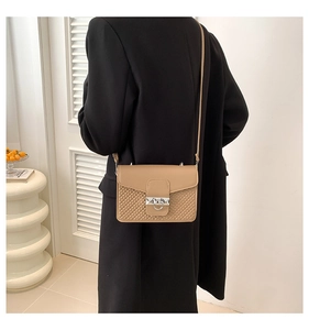 Detail of camel square crossbody bag featuring quilted texture and silver ring buckle