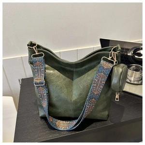 Detail of green hobo shoulder bag with ethnic patterned strap and round coin purse
