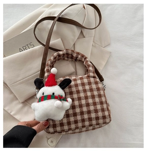 Dettaglio della borsa a tracolla a quadri marroni con un simpatico ciondolo a forma di peluche