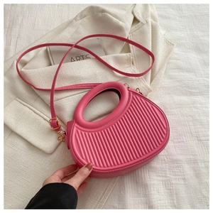 Detail der rosa plissierten PU-Handtasche mit rundem Griff und verstellbarem Schultergurt