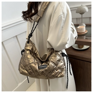 Detail of metallic gold quilted puffer bag with chic drawstring and logo patch