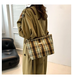 Classic plaid tote bag with golden chain strap and deer pendant on green coat model