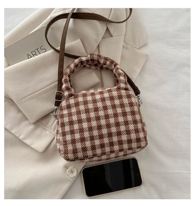 Dettaglio della mini borsa a quadri con tracolla e smartphone per confronto dimensioni