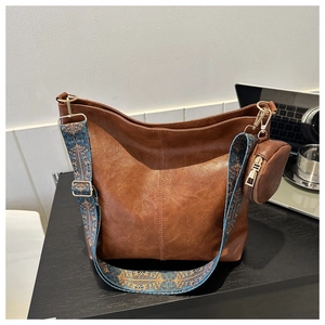 Detail of vintage brown PU leather bag with ethnic patterned wide strap and mini coin purse