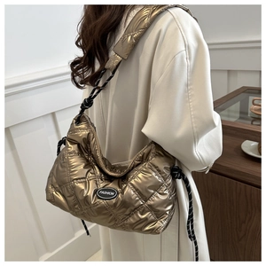 Detail of quilted metallic gold padded tote bag with FASHION label and crossbody strap