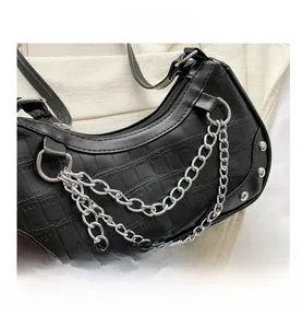 Détail du sac à main noir motif pierre avec chaînes argentées et rivets de style punk
