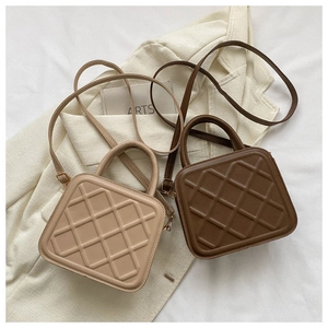 Detail view of beige and brown quilted faux leather handbags with crossbody straps