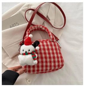 Dettaglio borsa in tweed a scacchi rossi con tracolla in pelle e ciondolo a cucciolo
