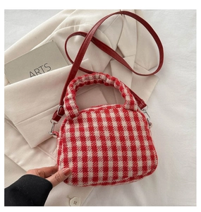 Dettaglio della trama in tessuto tweed a quadretti rosso e beige della borsa