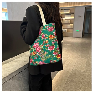 Detail of green floral canvas tote bag with traditional red peony and phoenix print