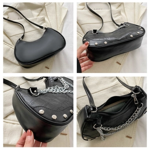 Détail du sac à bandoulière noir gaufré crocodile avec clous argentés et chaîne décorative