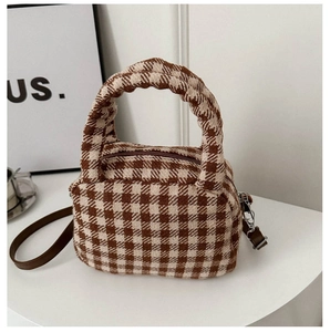 Dettaglio della borsa a quadri marrone e beige in tweed con tracolla in pelle