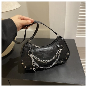 Détail du sac noir effet croco avec chaîne argentée et finitions métalliques chic