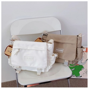 Détail de sacs bandoulière en nylon avec boucle à rabat et breloque en peluche