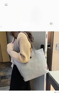 Detail of grey-white linen tote bag with brown leather handles worn on the shoulder