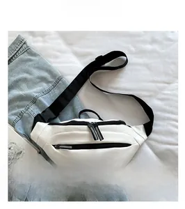 Dettaglio di un marsupio bianco in nylon con cerniere nere e tracolla regolabile