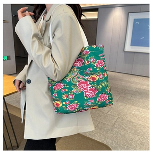 Detailed shot of green floral canvas tote bag with traditional peony and phoenix patterns