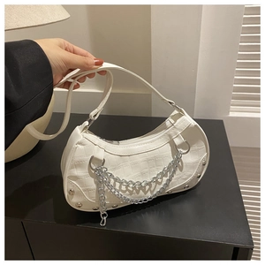 Détail du sac à main blanc à texture crocodile avec décoration de chaîne argentée