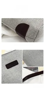 Close-up of light grey canvas tote bag with brown leather trim and FASHION logo tag