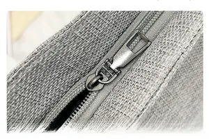 Detailed macro view of the silver metal zipper closure on the gray fabric tote bag
