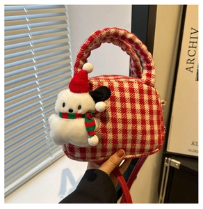 Dettaglio borsa a quadri bianchi e rossi con ciondolo a forma di cucciolo di Natale