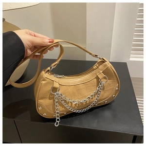 Détail de la texture crocodile kaki avec chaîne argentée et détails de rivets