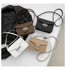Detail view of four textured crossbody bags in brown, black, white, and khaki colors