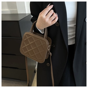 Chic brown quilted crossbody bag shown with a black blazer in a modern setting
