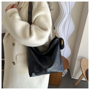 Chic black hobo bag with a wide ethnic woven strap and mini coin purse detail