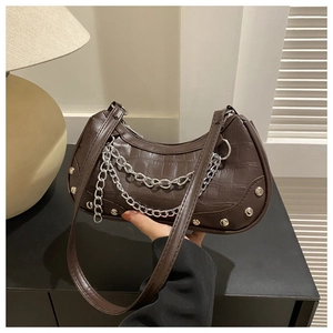 Détail du sac lune marron à motif crocodile avec chaînes et rivets argentés