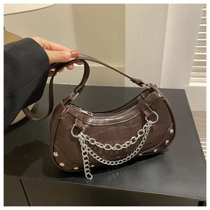 Détail du sac bandoulière marron foncé à motif crocodile avec chaînes argentées