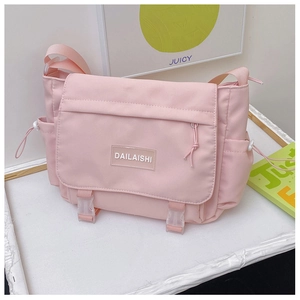 Détail de la sacoche en nylon rose avec fermeture à boucle et poche latérale à cordon