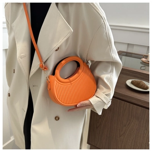 Detailansicht einer orangefarbenen Halbmond-Tasche mit Streifenstruktur als Umhängetasche