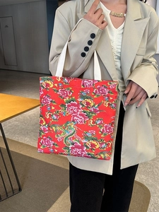 Fashionable floral tote bag with ethnic pattern carried by model in casual suit