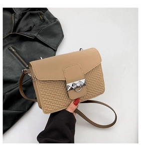 Detail of light khaki crossbody bag with silver buckle and embossed heart pattern