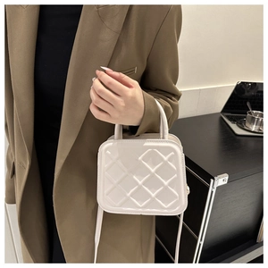 Close-up of a white quilted mini crossbody bag with textured geometric diamond pattern