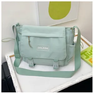 Détail du sac messager en nylon vert clair avec fermeture à boucle et poche latérale