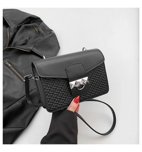 Close-up of black crossbody bag with embossed heart texture and silver metal lock