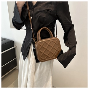 Close-up of brown quilted faux leather handbag with elegant rhombus pattern and handle