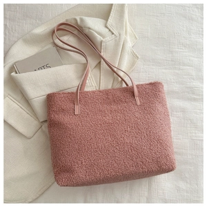 Détail d'un grand sac cabas rose en peluche avec ses anses en cuir assorties