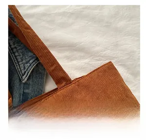 Detailed close-up of brown corduroy tote bag showing vertical ribbed fabric texture