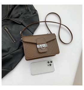 Detail view of brown PU leather crossbody bag featuring geometric texture and silver lock