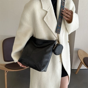 Chic black leather crossbody bag with ethnic patterned wide strap and mini round pouch