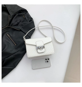 Detail of white crossbody bag featuring heart embossed texture and silver square ring buckle