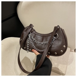 Détail du sac marron foncé motif pierre avec doubles chaînes argentées et rivets en métal